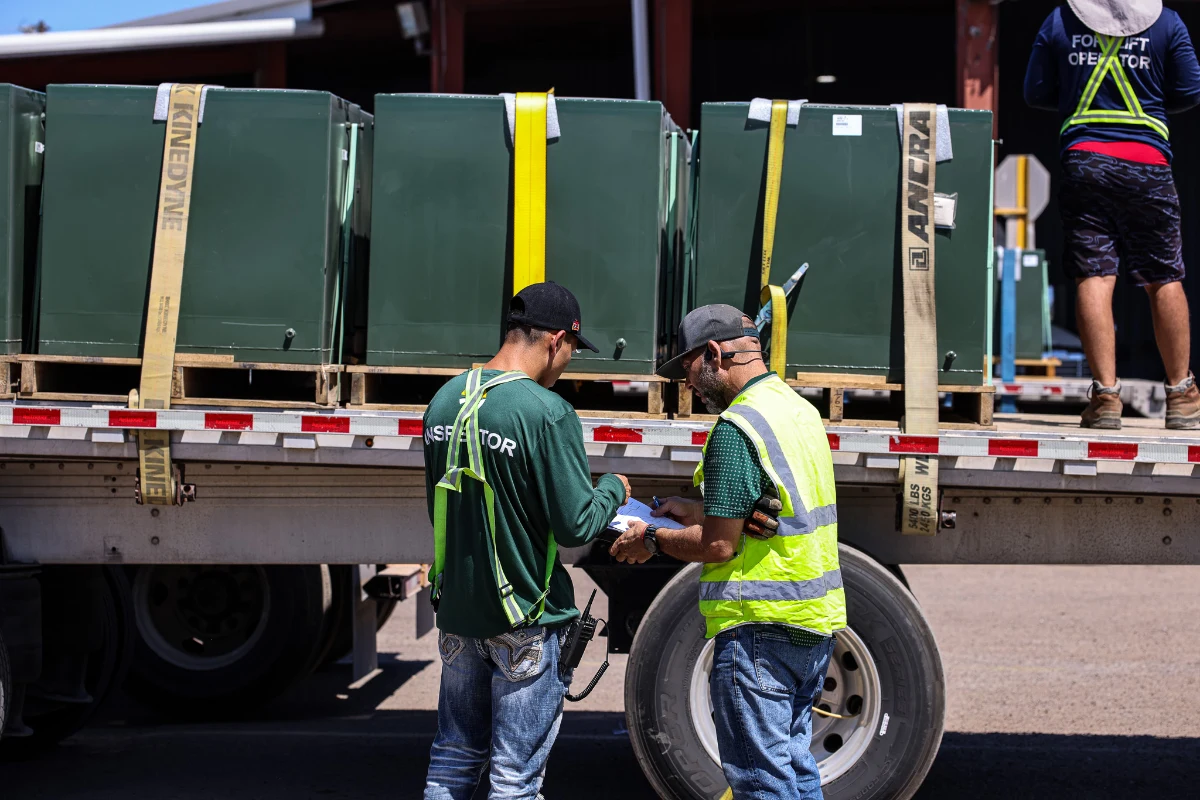 Sunline driver and inspector reviewing load documentation at the back of a trailer