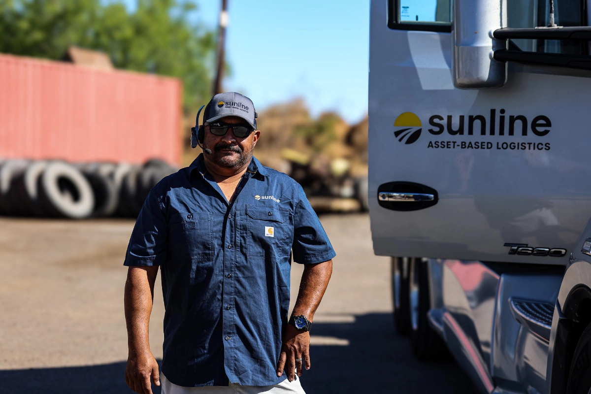 Male Sunline driver standing next to an open tractor door