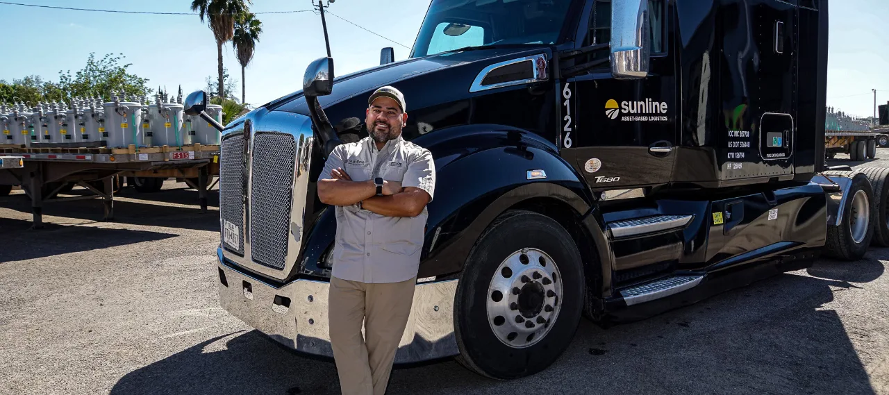 Male Sunline driver standing against a black tractor
