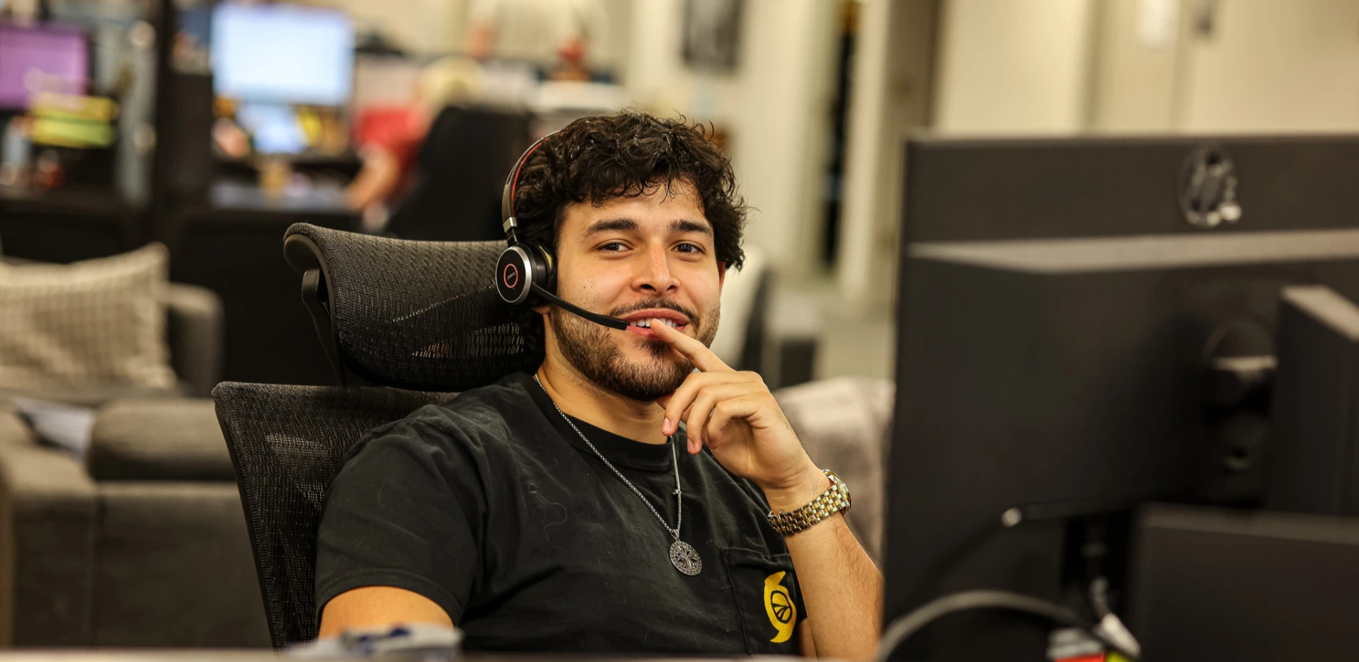 Male Sunline office employee wearing a headset and smiling at his desk