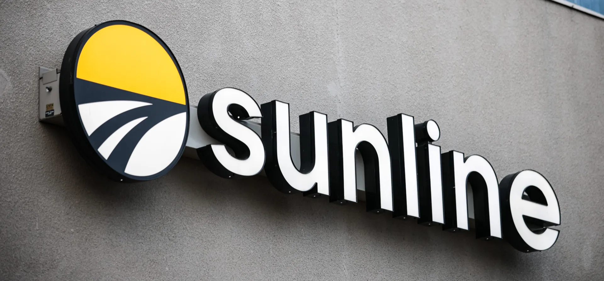 Sunline illuminated building sign mounted on an exterior wall