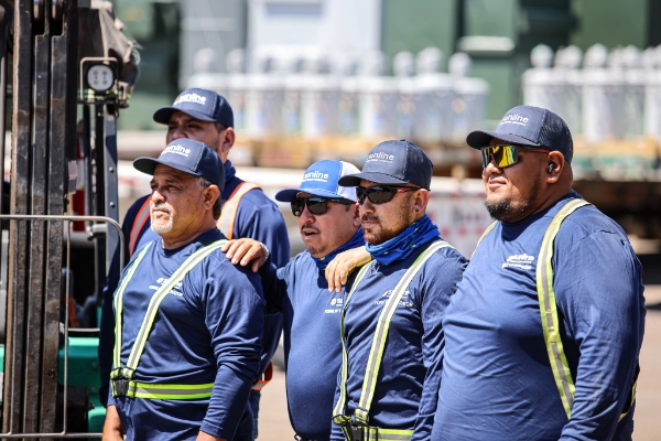 Group of male Sunline terminal employees in blue uniforms and safety vests at the terminal yard
