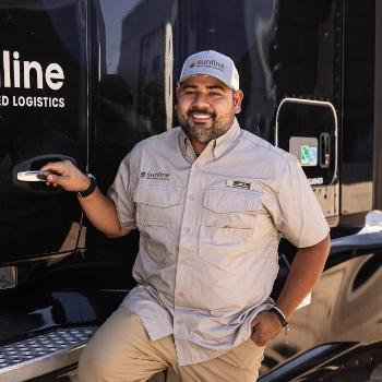 Andres Villarreal, Sunline driver, smiling and leaning against a Sunline tractor