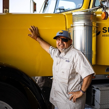 Jaime Valdez, Sunline driver, smiling and leaning against a Sunline tractor