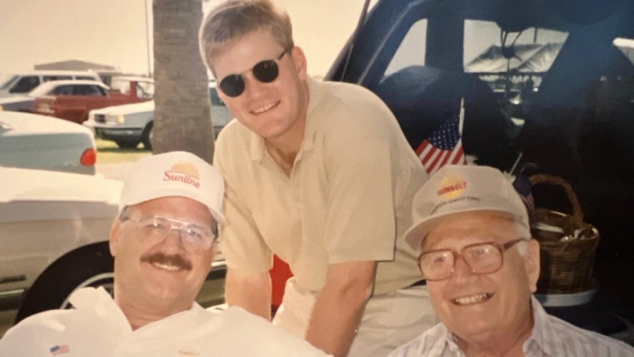 Vintage photo of John Flinn and early Sunline employees wearing Sunline and Sunbelt branded caps