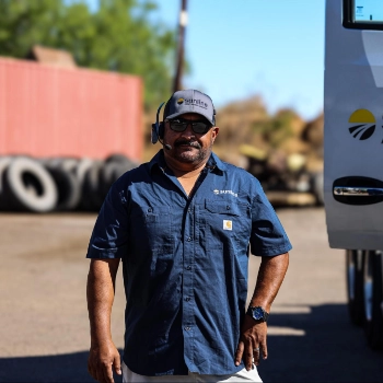 Robert F., Sunline driver, standing next to the open door of a Sunline tractor in a truck terminal