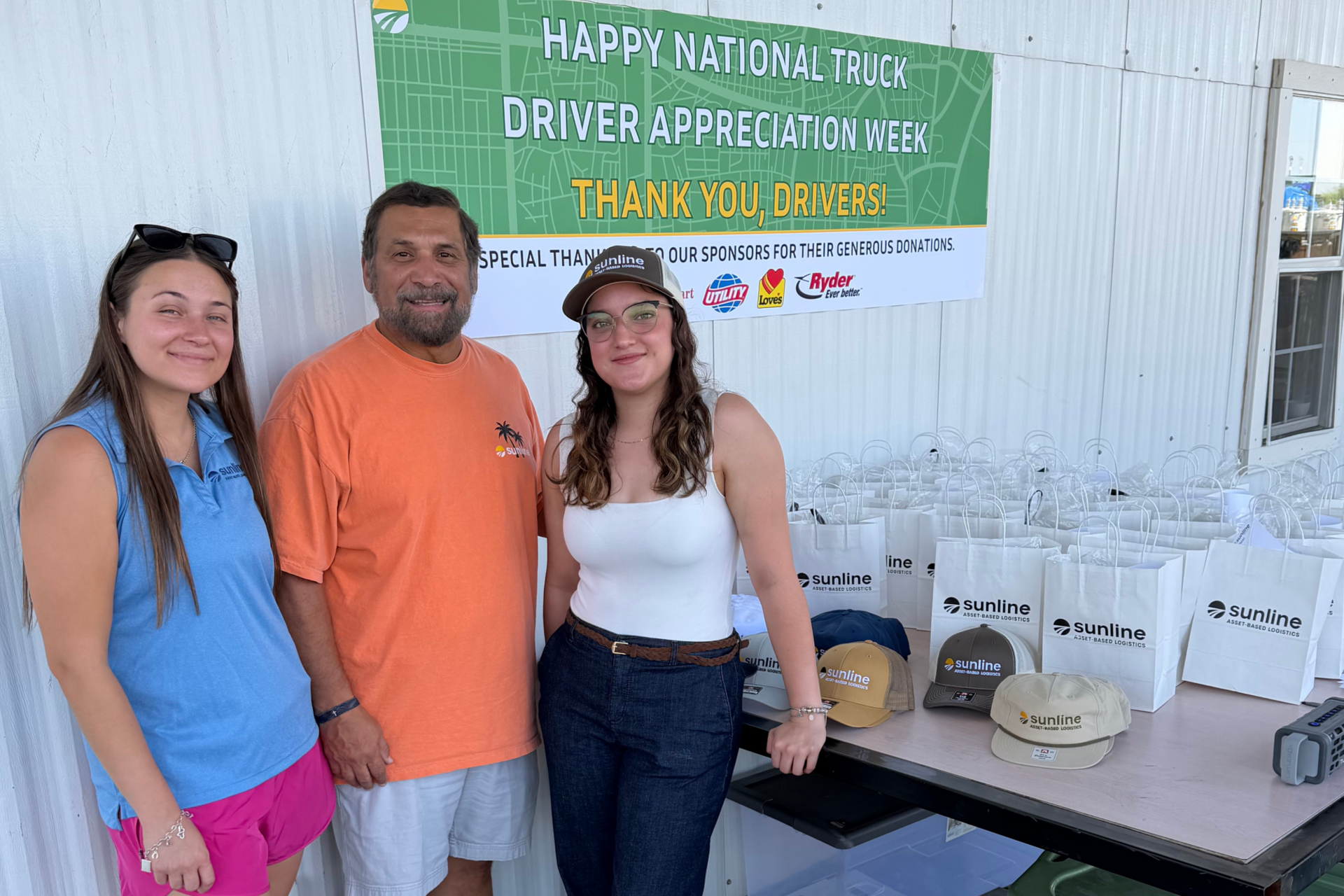 Group photo of three Sunline employees handing out gifts to drivers